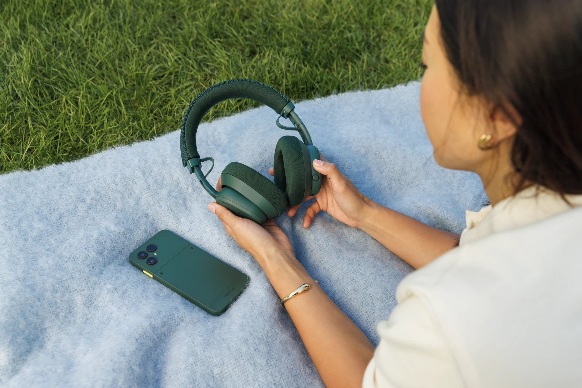 Fairbuds XL resting in a listener’s hands outdoors
